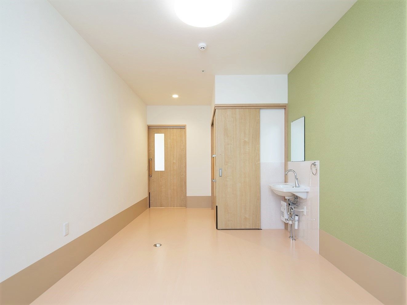洗面台とトイレが設置してある施設内の居室の様子。オールバリアフリーの床が見えている様子