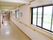 白を基調とした清潔感のある廊下である。窓から外光がたっぷりと差し込み、壁には手すりが設置されている。
