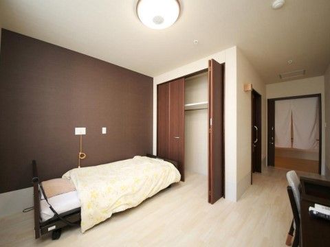 白いフローリングの床に、介護用ベッドと机と椅子が置かれている。入り口はスライド式のドアで、室内に段差は無い。壁には、緊急時用のコールがある。