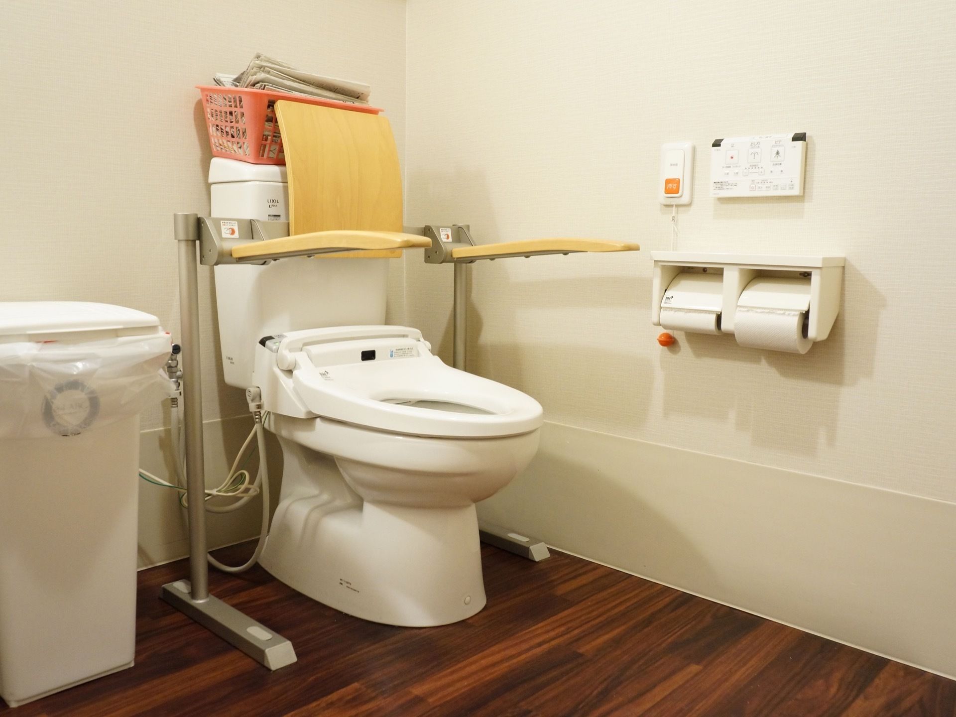 トイレスペースは広く、床は全面フラットに整えている。洋式便器には跳ね上げ式の手すりと背当てパッドを取り付けている。
