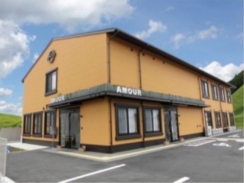 １階の屋根には、施設名がアルファベットで記してある。また屋根の下には、施設のマーク見える。太い窓枠が特徴である。