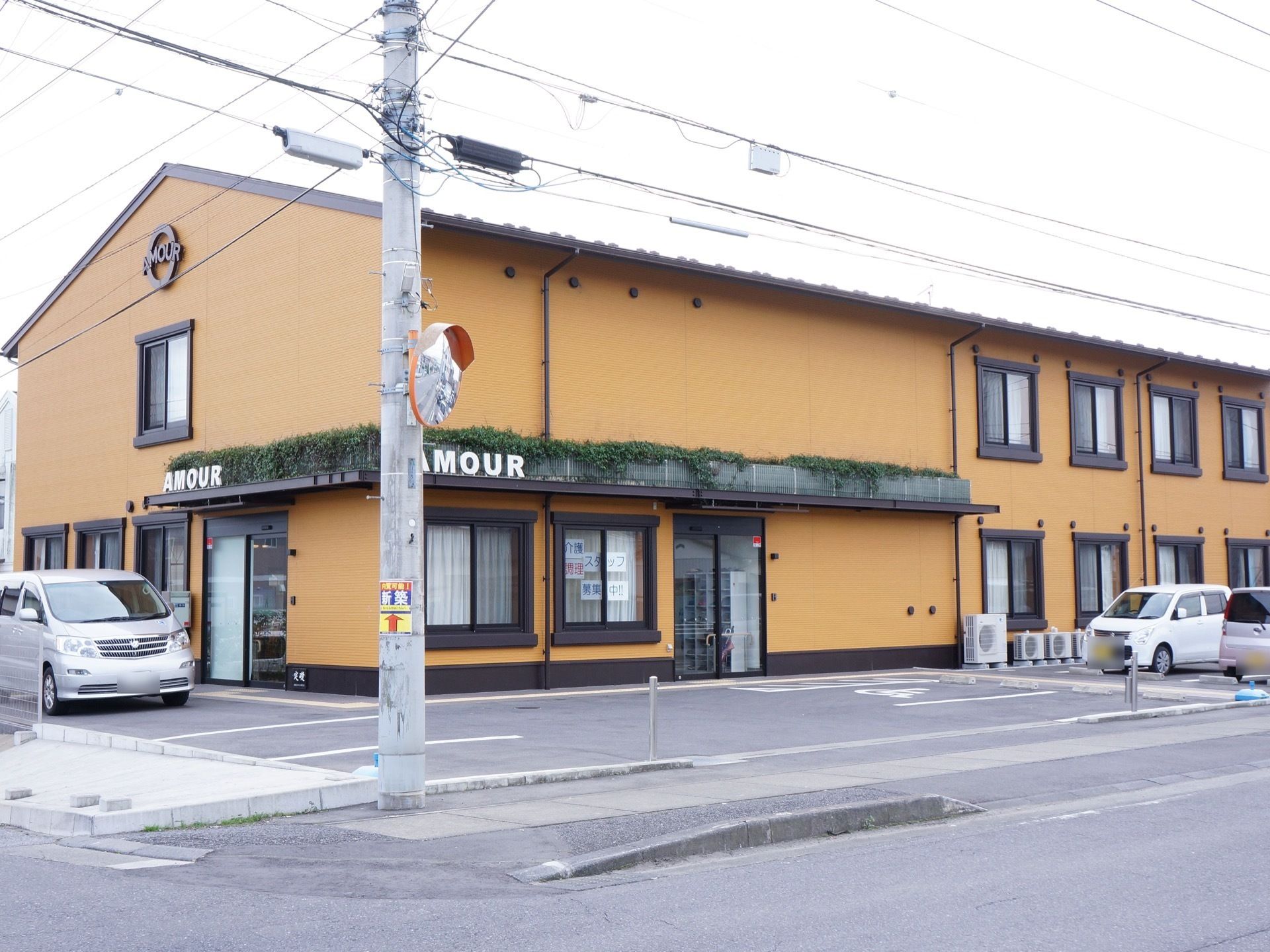 2階建ての建物はブラウンの外壁で植物も飾られたおしゃれな外観である。施設名が大きなアルファベットで書かれ、わかりやすい。