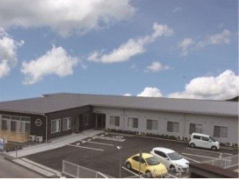 広い駐車スペースと白と黒を基調としたモダンな平屋建ての建物