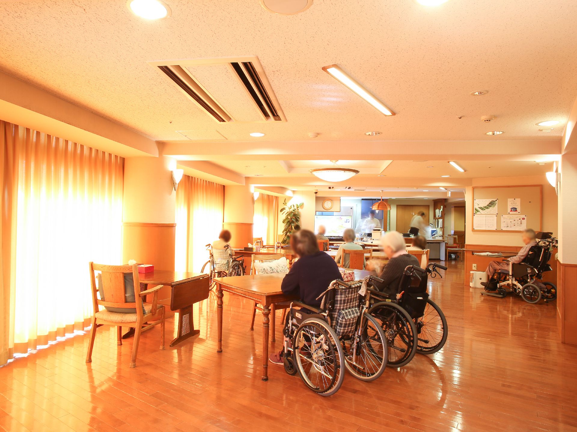 広いラウンジにあるテーブル、椅子に座ることができる人、車椅子の人双方に対応している。一人用の机もある。