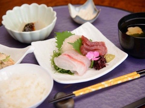紫色のお盆に食事が配膳されている。高タンパク、低カロリー、低糖質と身体に嬉しいお刺身やサラダ、お吸い物、ご飯がある。