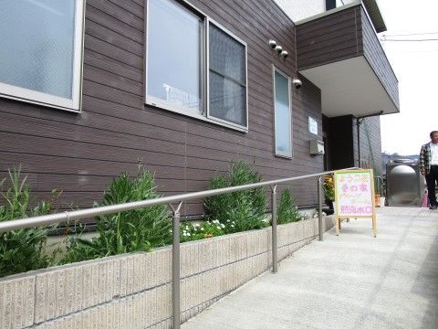 2階建て施設の入口には、手すり付きスロープが設置されている。そばには植え込みを完備し、季節の花々が入居者様の笑顔を誘う。