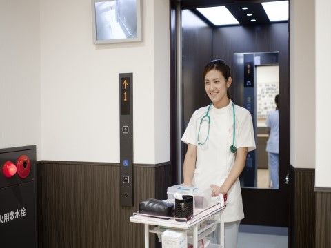 ワゴンを押しながらエレベーターから出てくる看護スタッフ