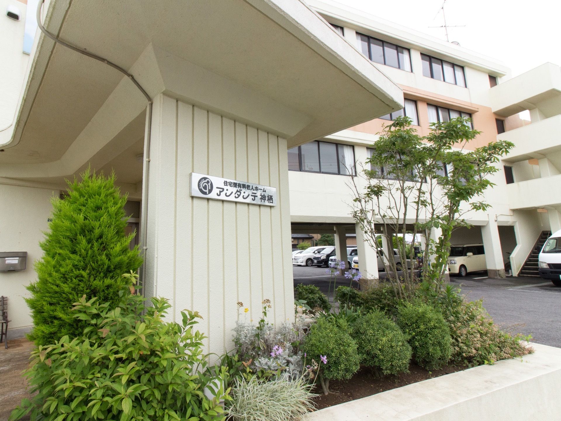 車が横つけできるように大きなひさしがついている。さらに木の植え込みにより、心を和ませるように配慮がされている。