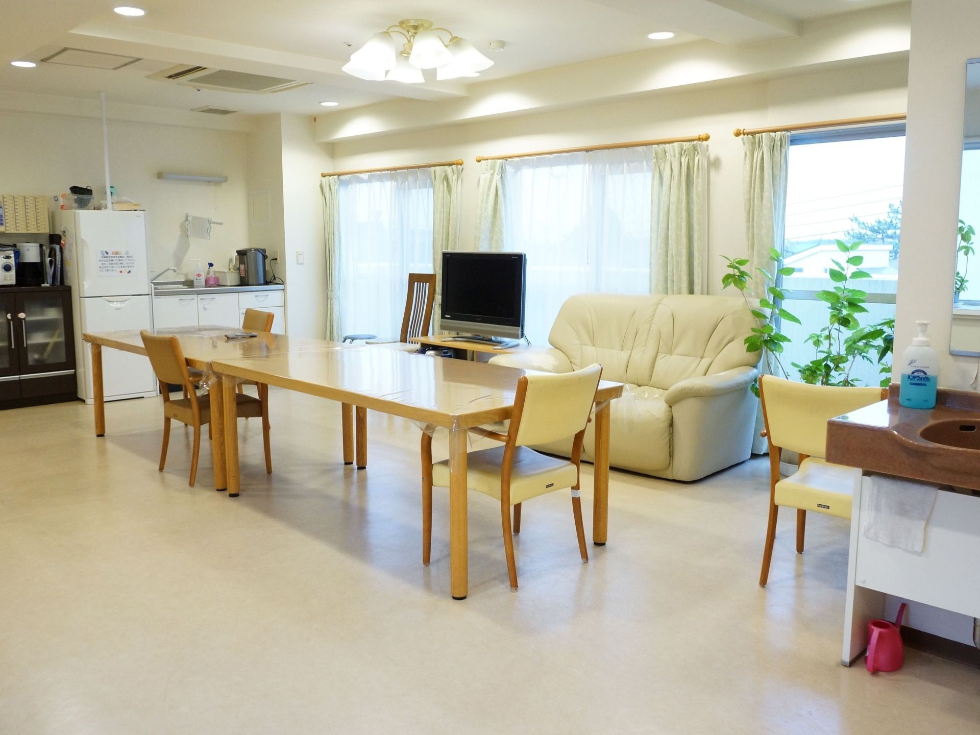 共用スペースにはイスだけではなく、白いソファも置かれている。またフロアには簡易キッチンがあり、テレビを設置している。