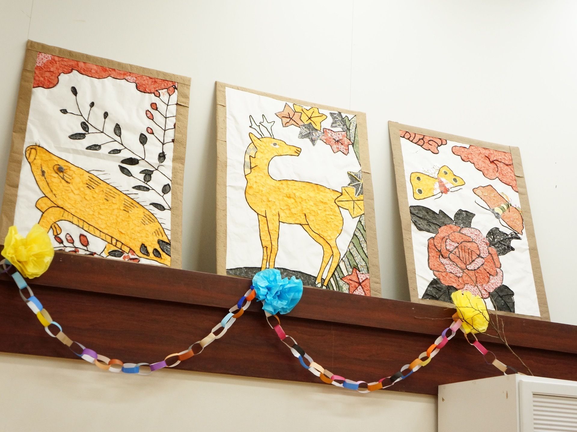 共用スペースの壁には折り紙で作った輪飾りがあり、ディスプレイ用の棚には手作りのオブジェが飾られている。
