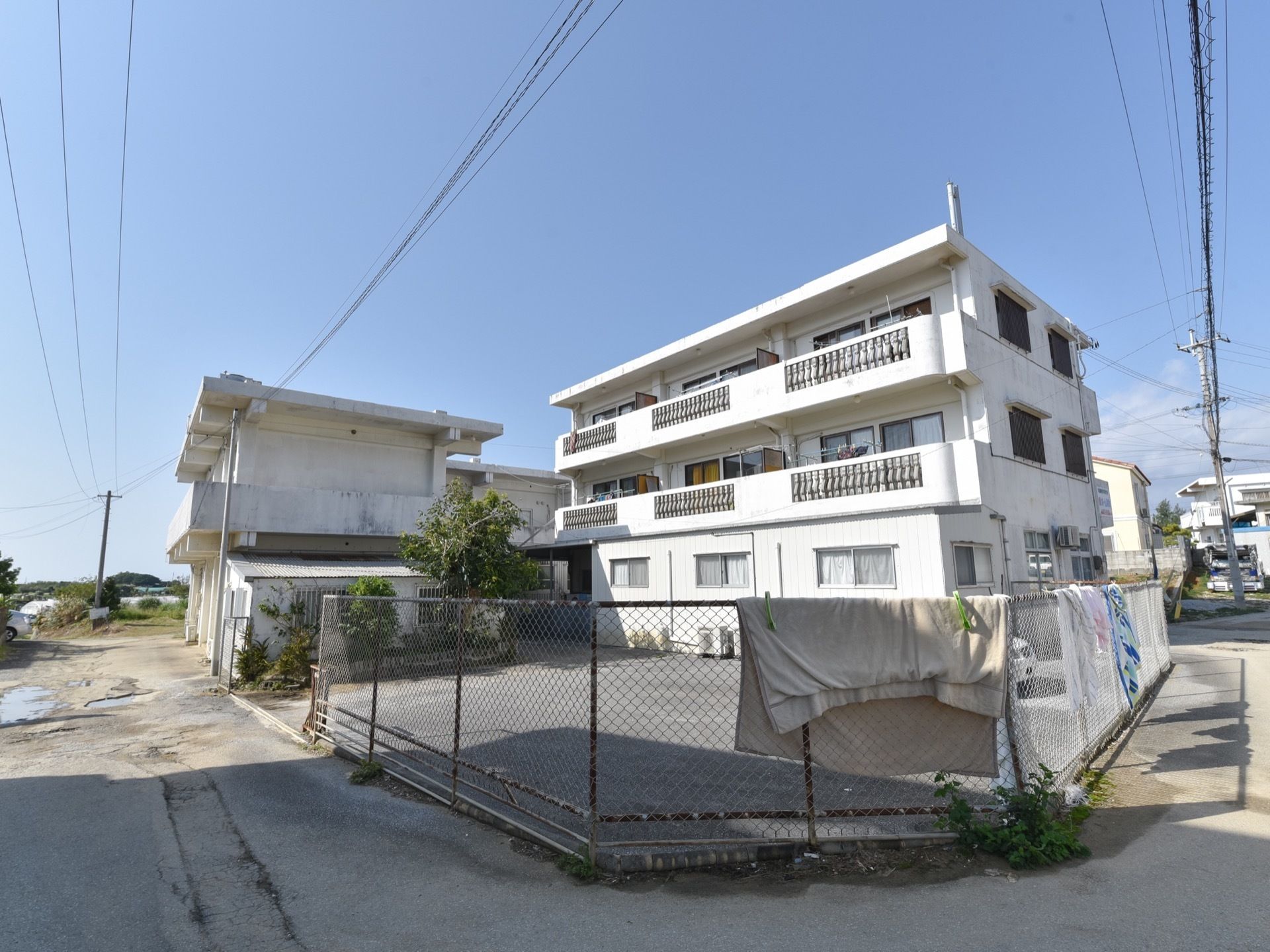 真っ白でお城のような3階建ての建物である。各居室にはバルコニーが完備されている。周辺は閑静な住宅地である。