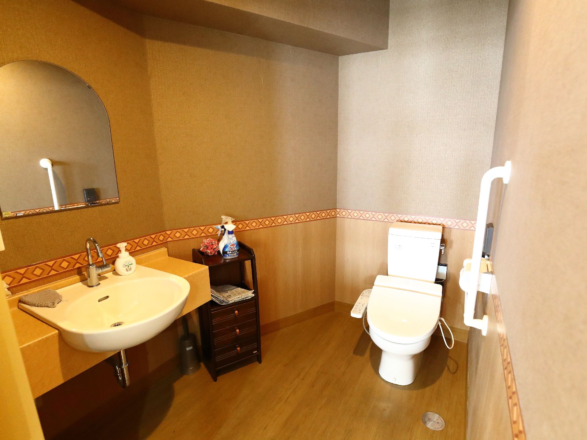 トイレと洗面台が同じスペースにまとめられている。洗面ボウルの上には鏡があり、下には車椅子が入れる空間がある。