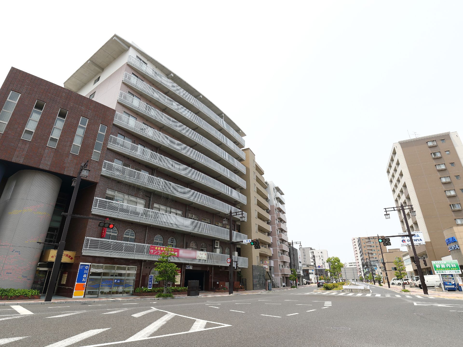 施設は9階建ての茶色いビルである。2階以上には各階にベランダが設置されている。2階部分に施設名が表示されている。