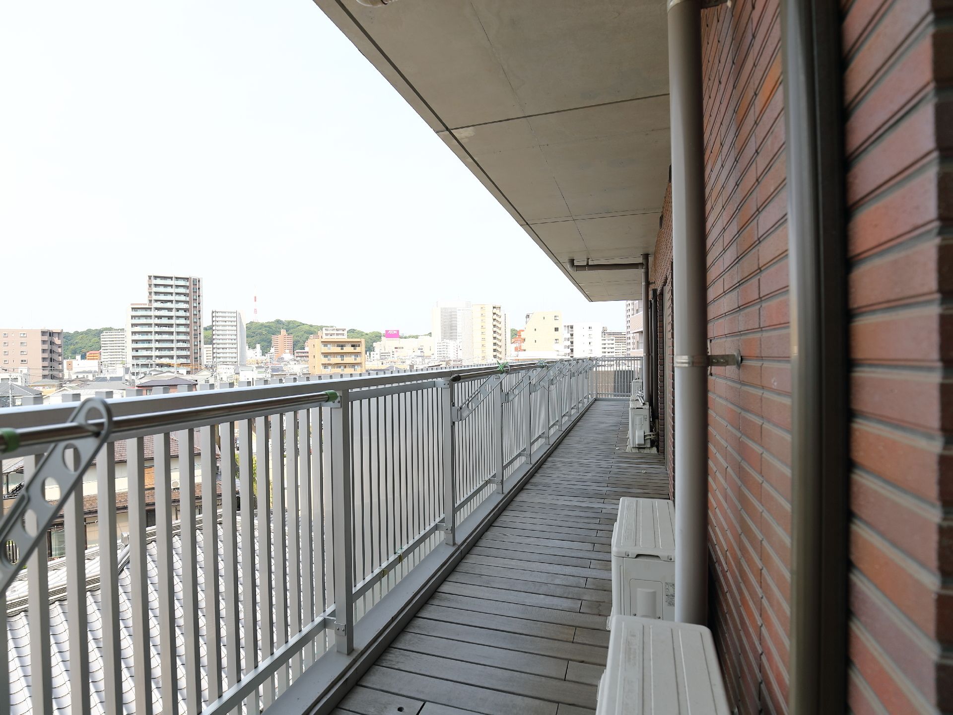 ベランダには物干しざおが設置されている。目の前に視界を遮る建物がないので遠くまで見渡すことができる。