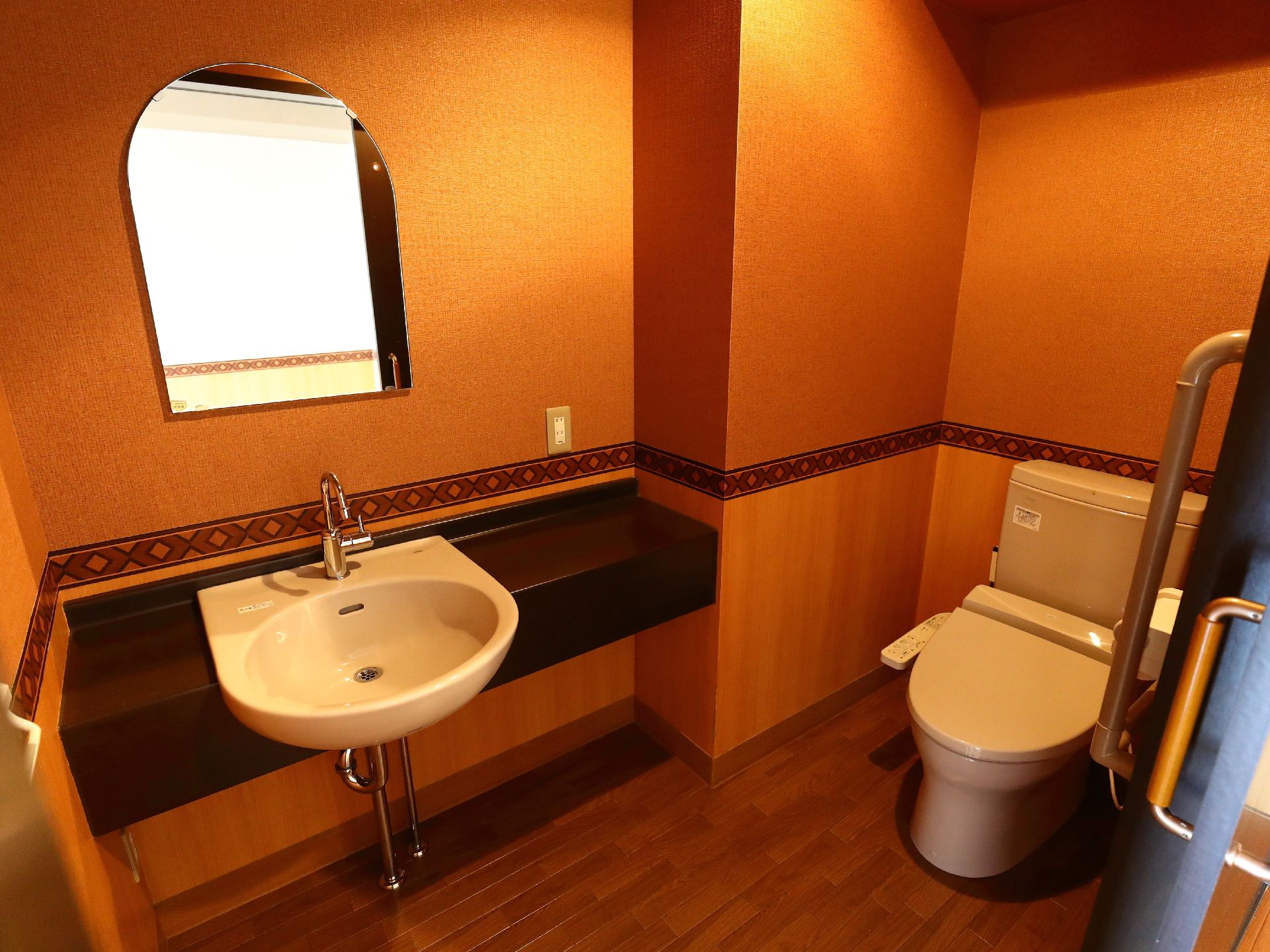 車いすでも十分入れる広いトイレには、手すりが設置されている。手洗い場も車いすの方が使いやすい高さになっている。