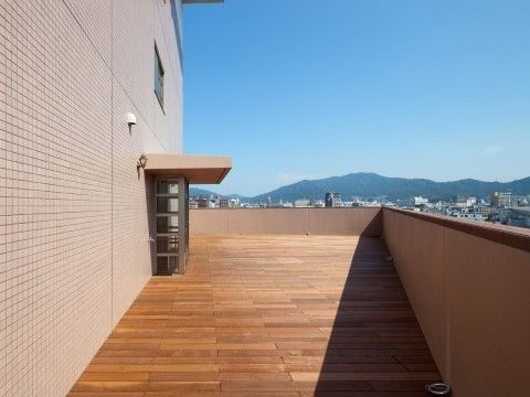 施設に設けられている、さわやかな空気を感じることができる屋上のウッドデッキスペース