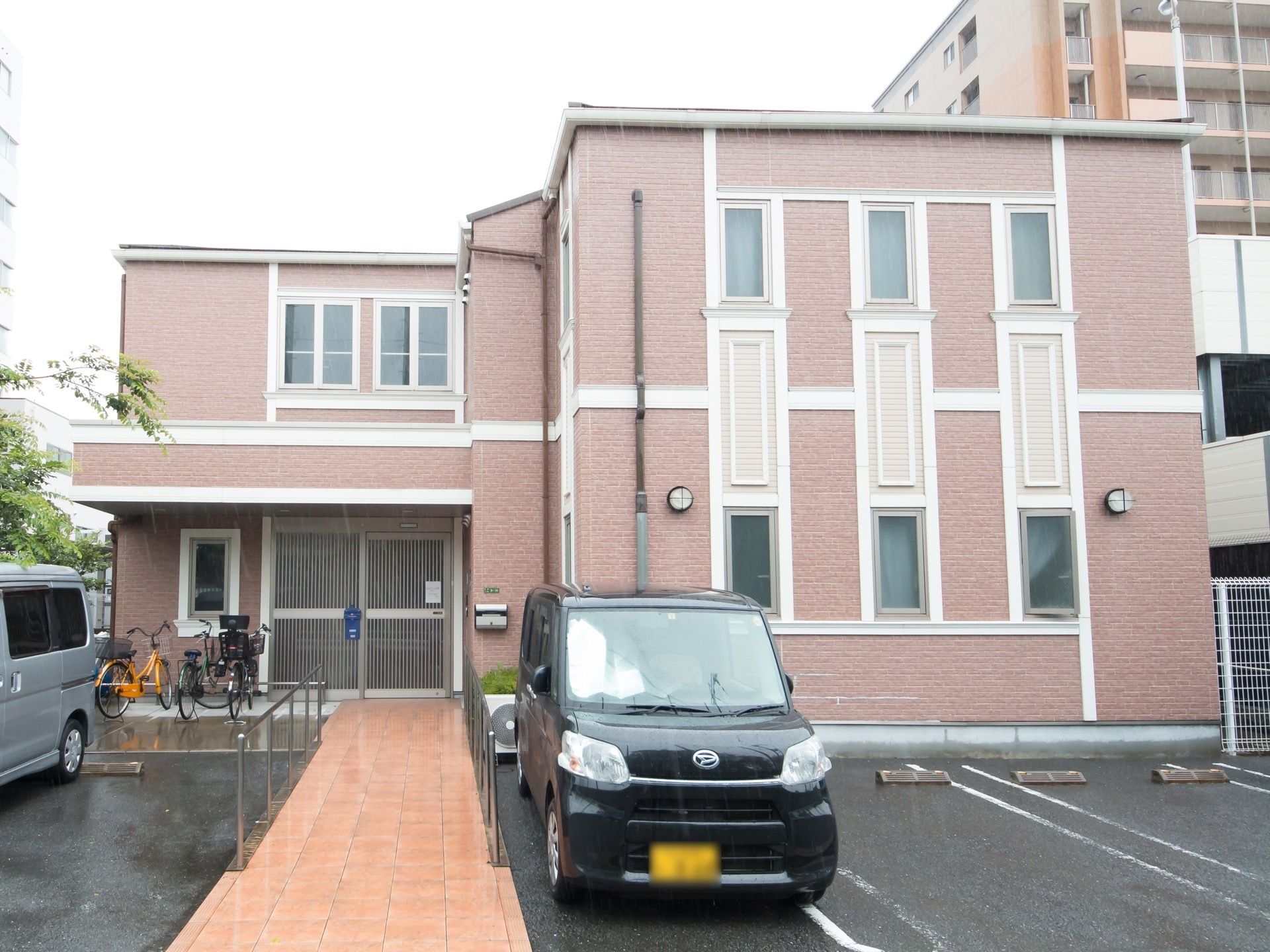 えんじ色と白色の小規模な建物である。駐車スペースと自転車を止めるスペースがあり、玄関まではスロープとなっている。