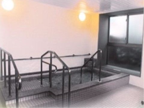 出入りのための手すりと高さを変えた段が設けられた浴槽