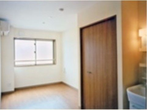 室内の壁は白、クローゼットの扉は濃い茶色の居室の一例