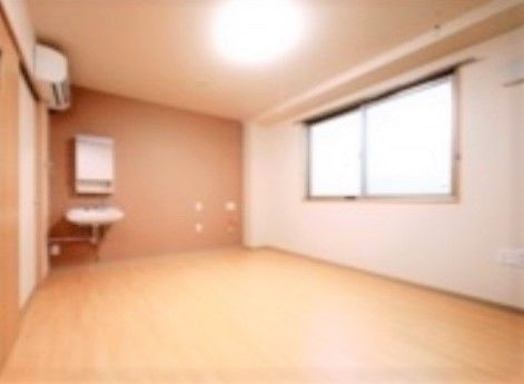 あたたかみのあるスモークピンクに塗られた壁面がある居室
