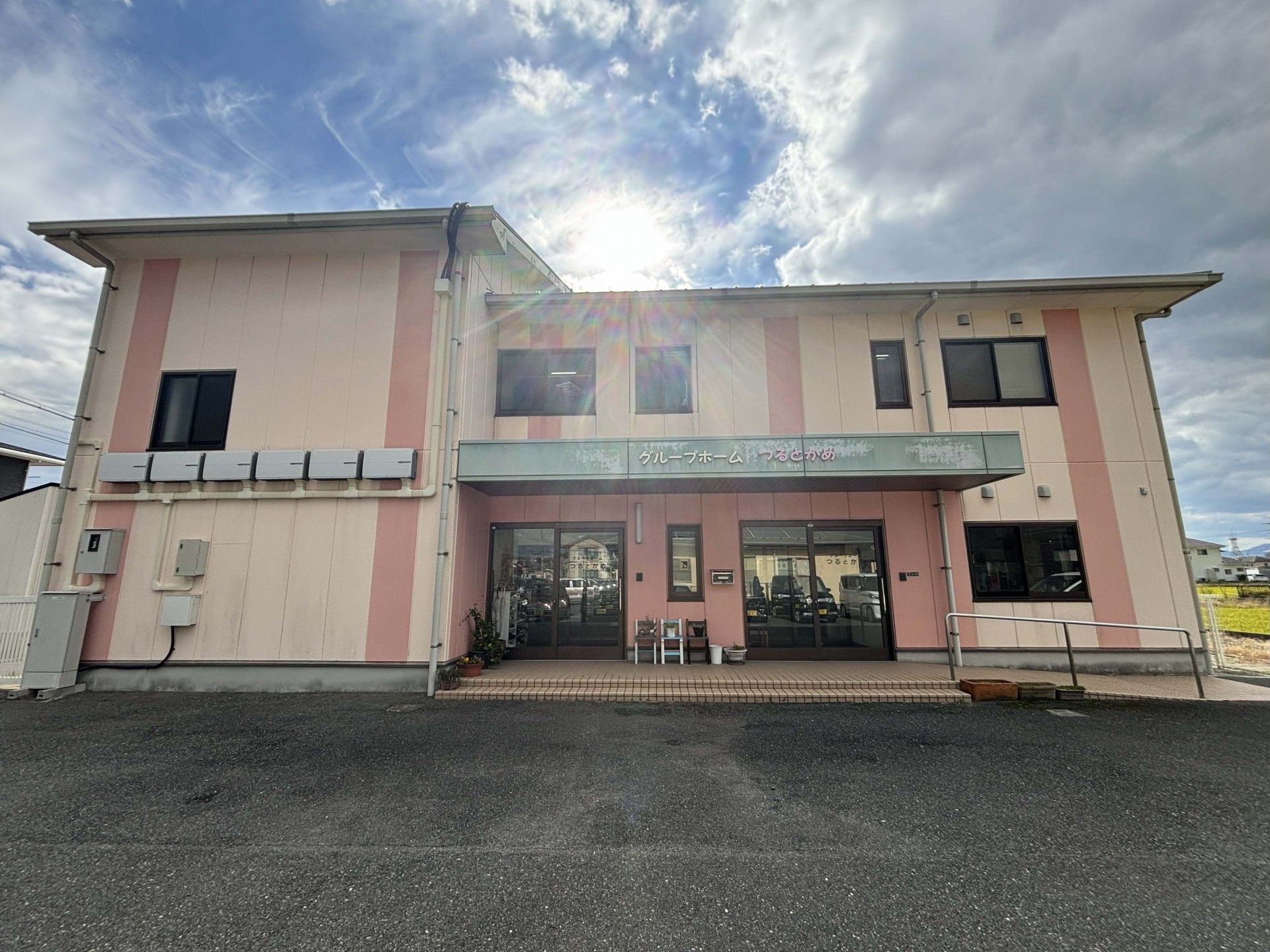 施設のベランダ部分から遠くの景色を眺める入居者様の様子