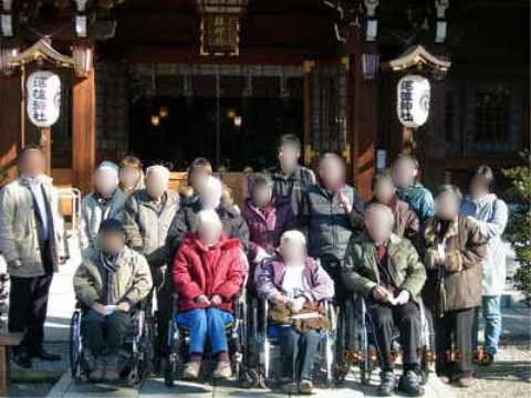 施設の行事で外出した先の神社の前で並んで写真に納まる入居者様