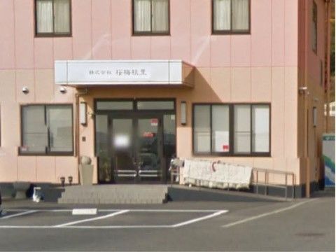 暖色系の２トーンカラーの2階建ての建物。玄関の正面は階段だが、横に手すり付のスロープも設置されている。