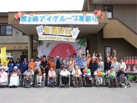 施設前で記念写真を撮る入居者