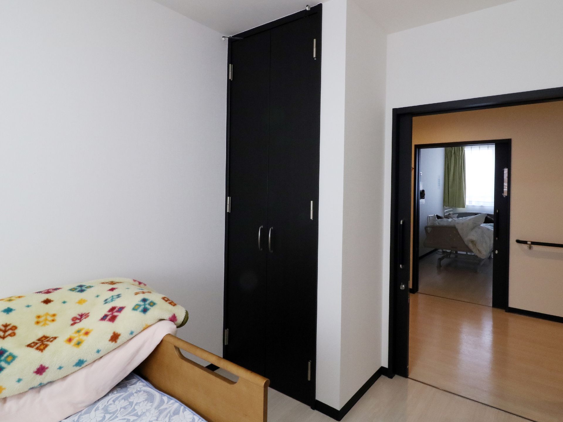 白い壁に黒い観音開きの扉のクローゼットがとてもオシャレ。部屋の出入口は、引き戸のため、部屋が広く感じられる。