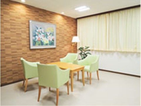 黄色のカーテンがつけられた、上品な雰囲気がただよう部屋である。角にはスタンド照明、観葉植物が置かれている。