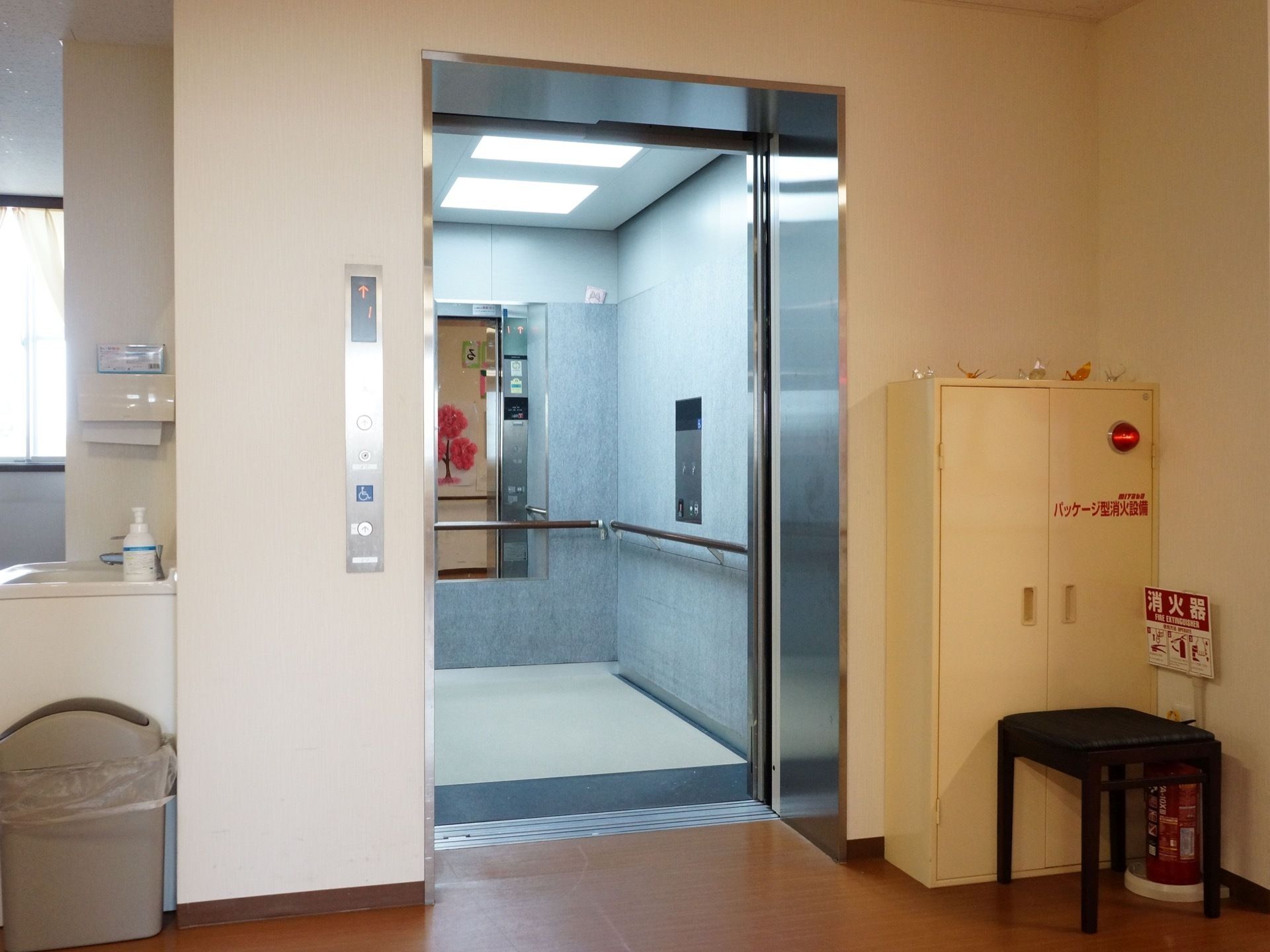 エレベーターが手洗い場のすぐ近くに設けられている。エレベーターの中には、鏡と手すりが設置されている。