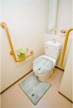 両側の壁にＬ字型の手すりが設置されており、ペーパーホルダーのそばには緊急時呼び出しボタンが備わっている。