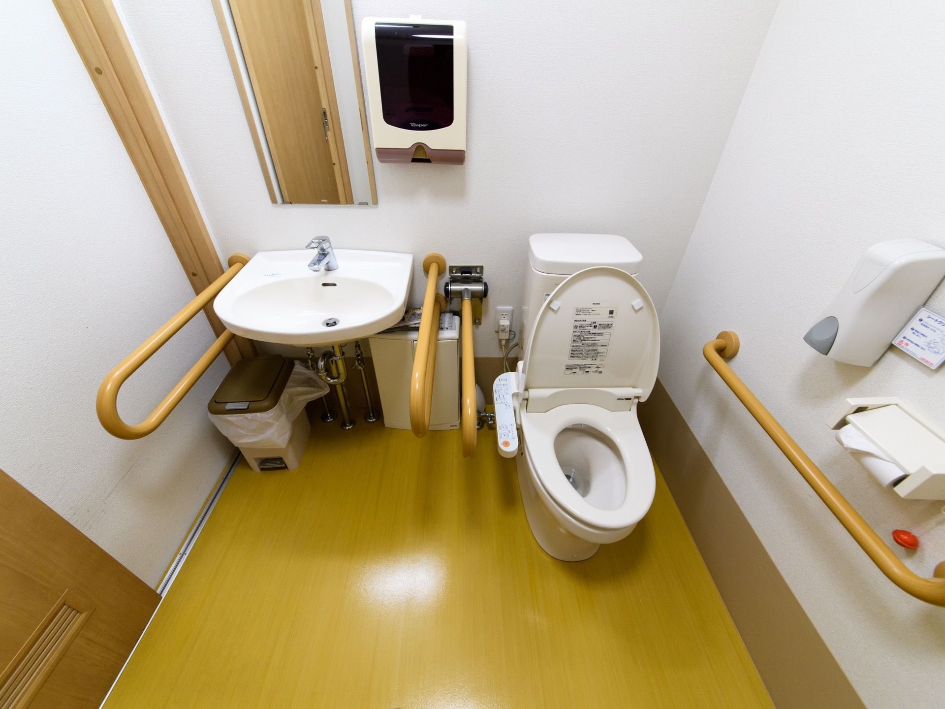 トイレのフロアには水汚れをふき取りやすい撥水する素材を使用している。便座を除菌するクリーナーが壁に設置されている。