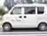 施設の送迎車である。助手席のドアに、施設名が表示されている。後部座席のドアは、横開きタイプの車である。