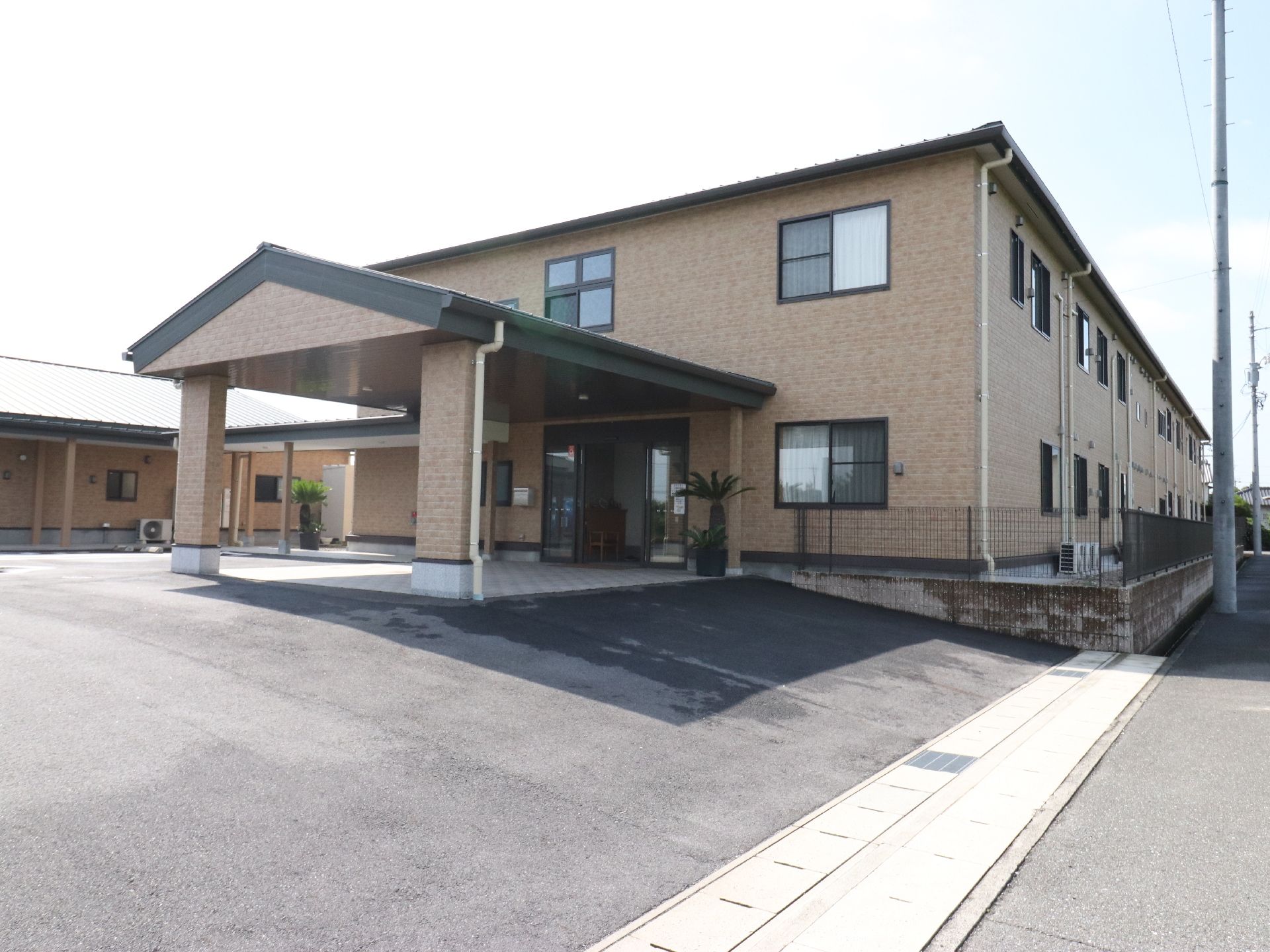 施設の建物は、長方形になっている。高齢者向け住宅の横に、同様の形状をしたデイサービスの建物が並んでいる。