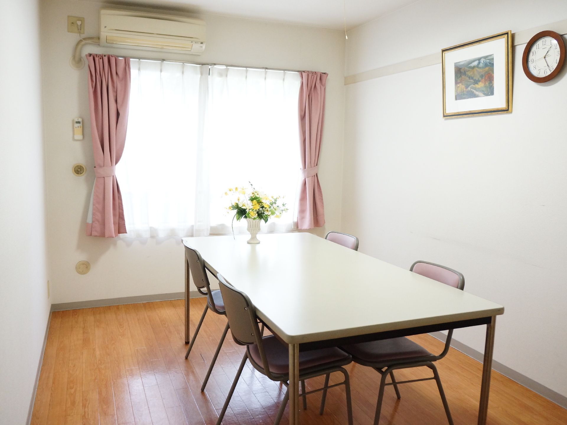 窓の大きい明るい雰囲気の面談室。4人掛けのテーブルと椅子が中央に置かれている。エアコンが備わっているので暑い夏も快適である。