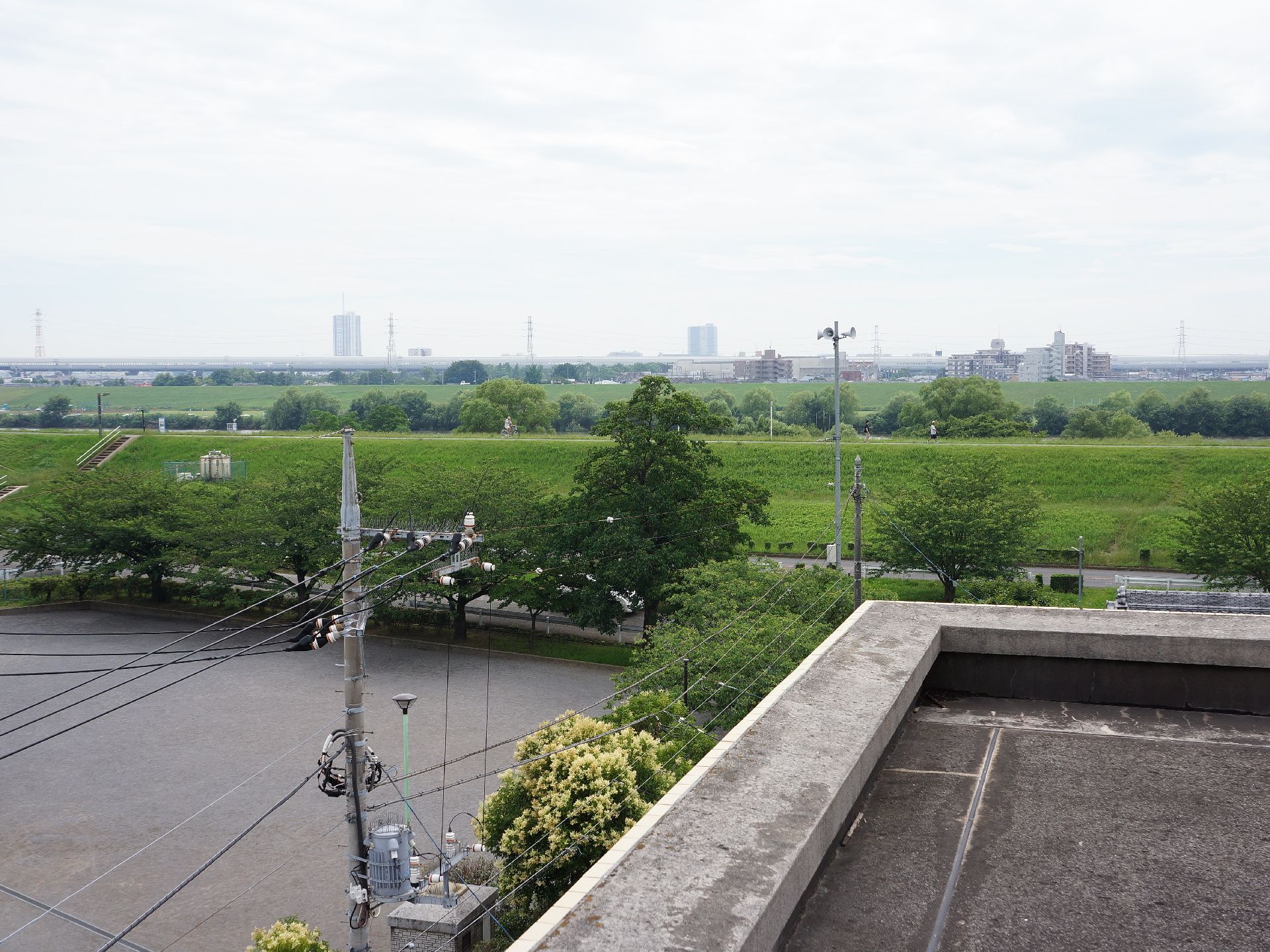 施設の周辺は緑がいっぱいあり、近くは河川敷になっている。天気の良い日の散歩には良いところ。屋上からの眺めは高い建物がないため大変良い。