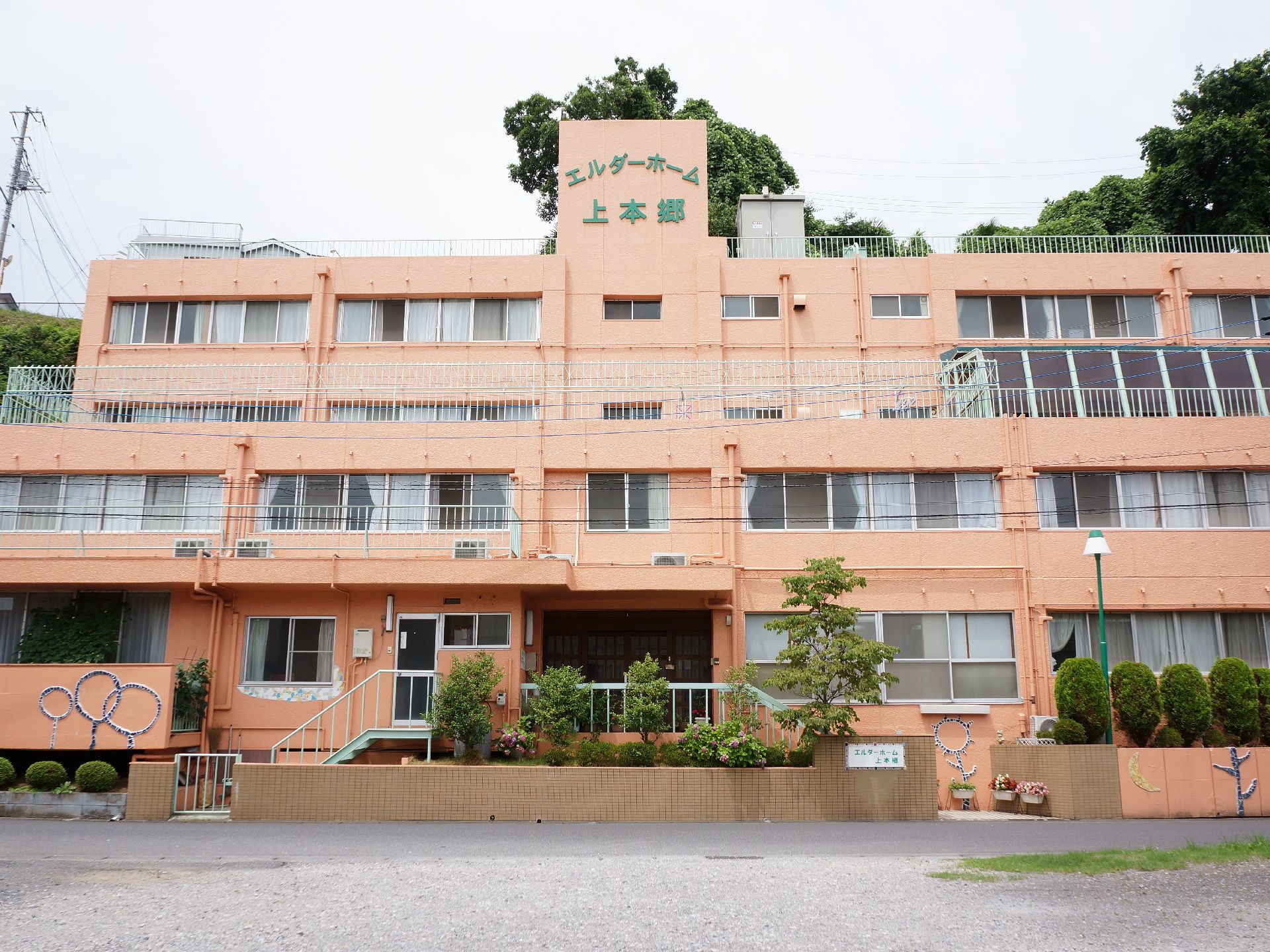 4階建ての施設にはたくさんの窓が並び、1階部分などには外壁に絵が描かれている、温かみを感じさせる特徴的な外観。