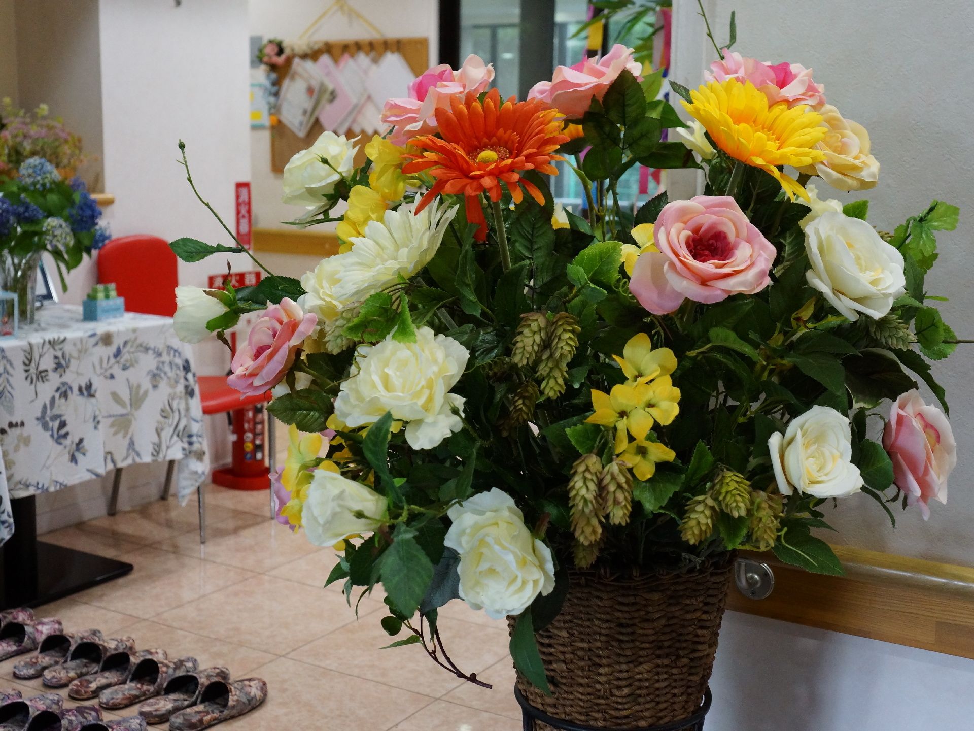 建物の入り口を入ると色とりどりの花が飾られているのが目に入る。玄関にはスリッパが何組も並べられている。