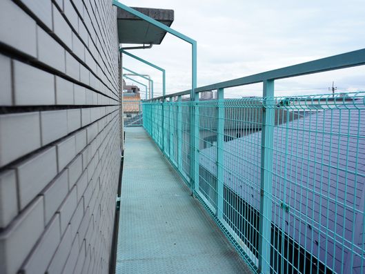 3階には緑色の長くつながったベランダがついていて、いろいろなドアから出ることができる。洗濯物を干す場合もある。"