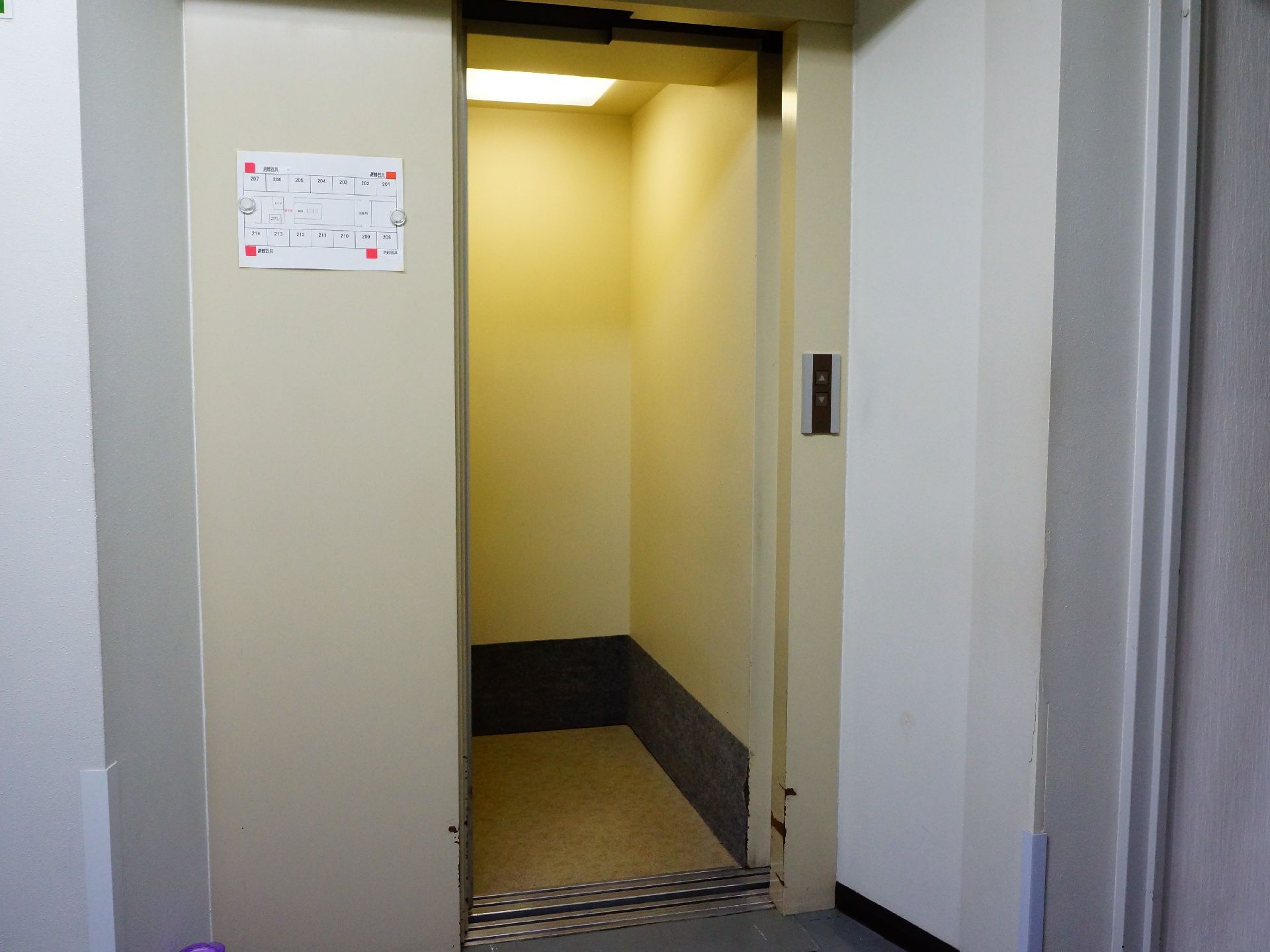 施設内にはエレベーターを設置。足の不自由な方でも快適に移動が出来るように配慮されている。ドアの横には張り紙が貼られている。