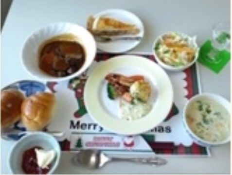 ロールパンやシチュー、肉料理などが並びデザートも添えられた食事例