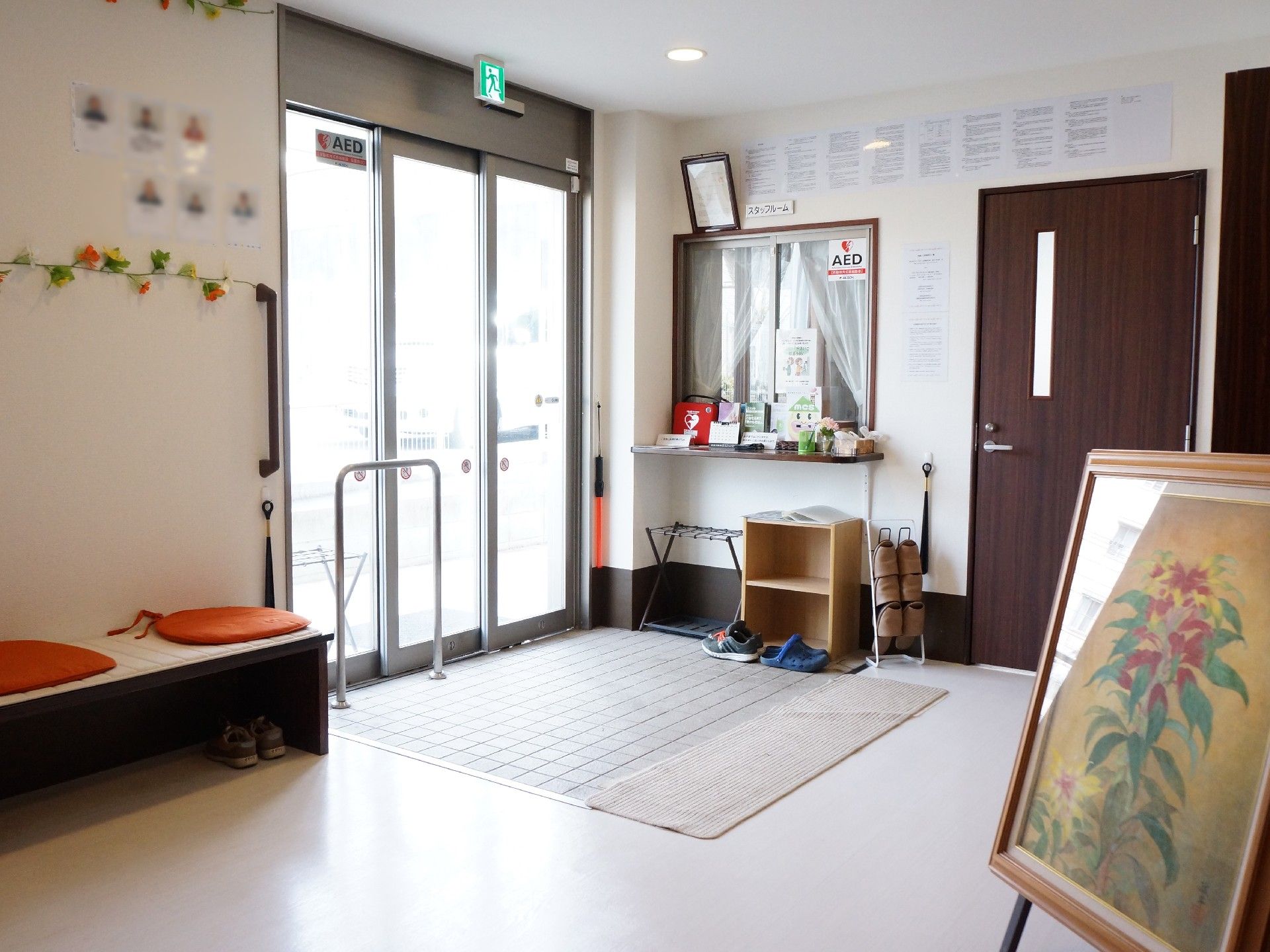 絵画を置いた施設エントランス。オレンジ色の座布団が雰囲気を明るくしている。