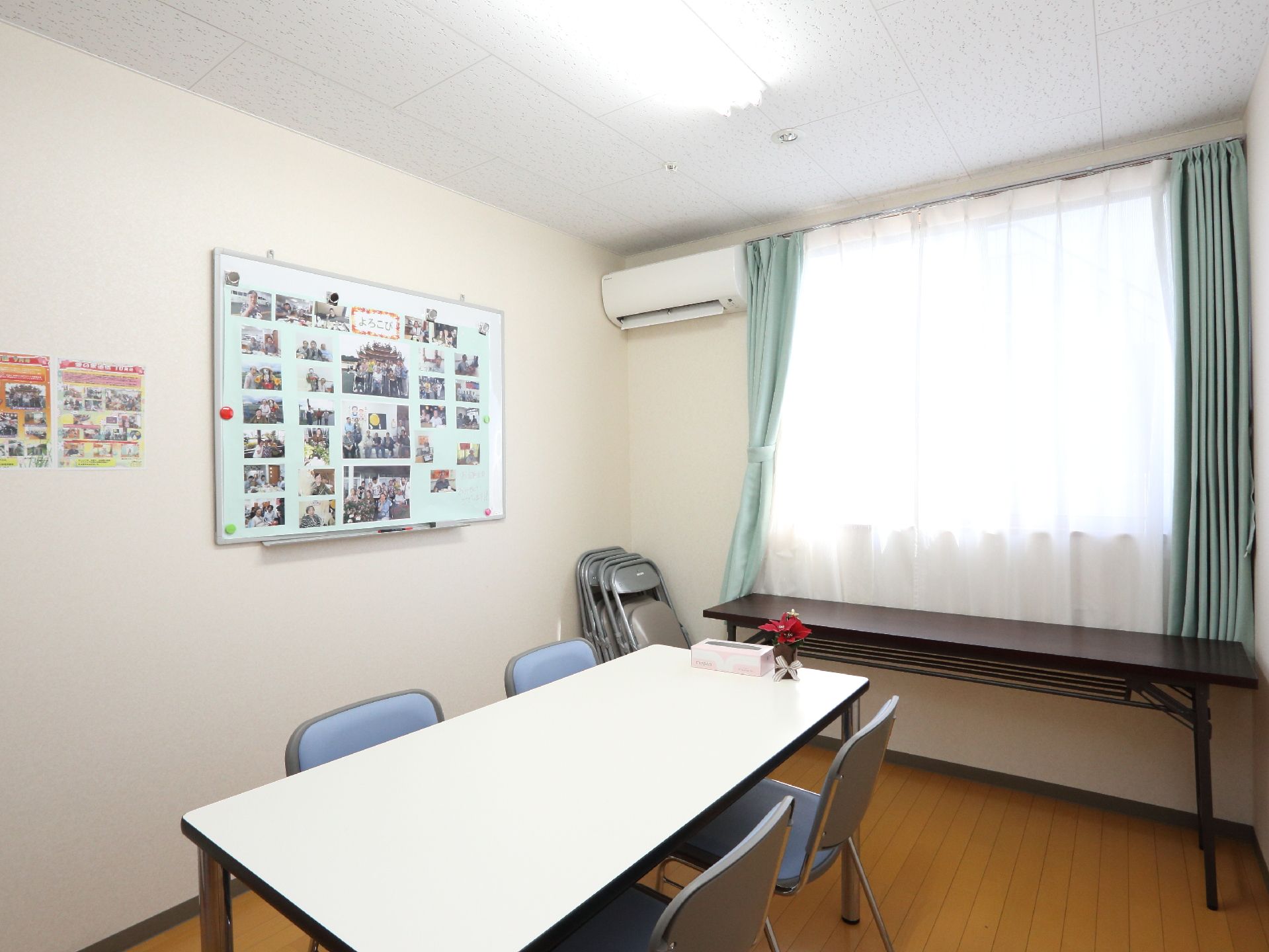 談話室にはテーブルと椅子が置かれている。また壁にはホワイトボードがあり、空調設備が取り付けられている。