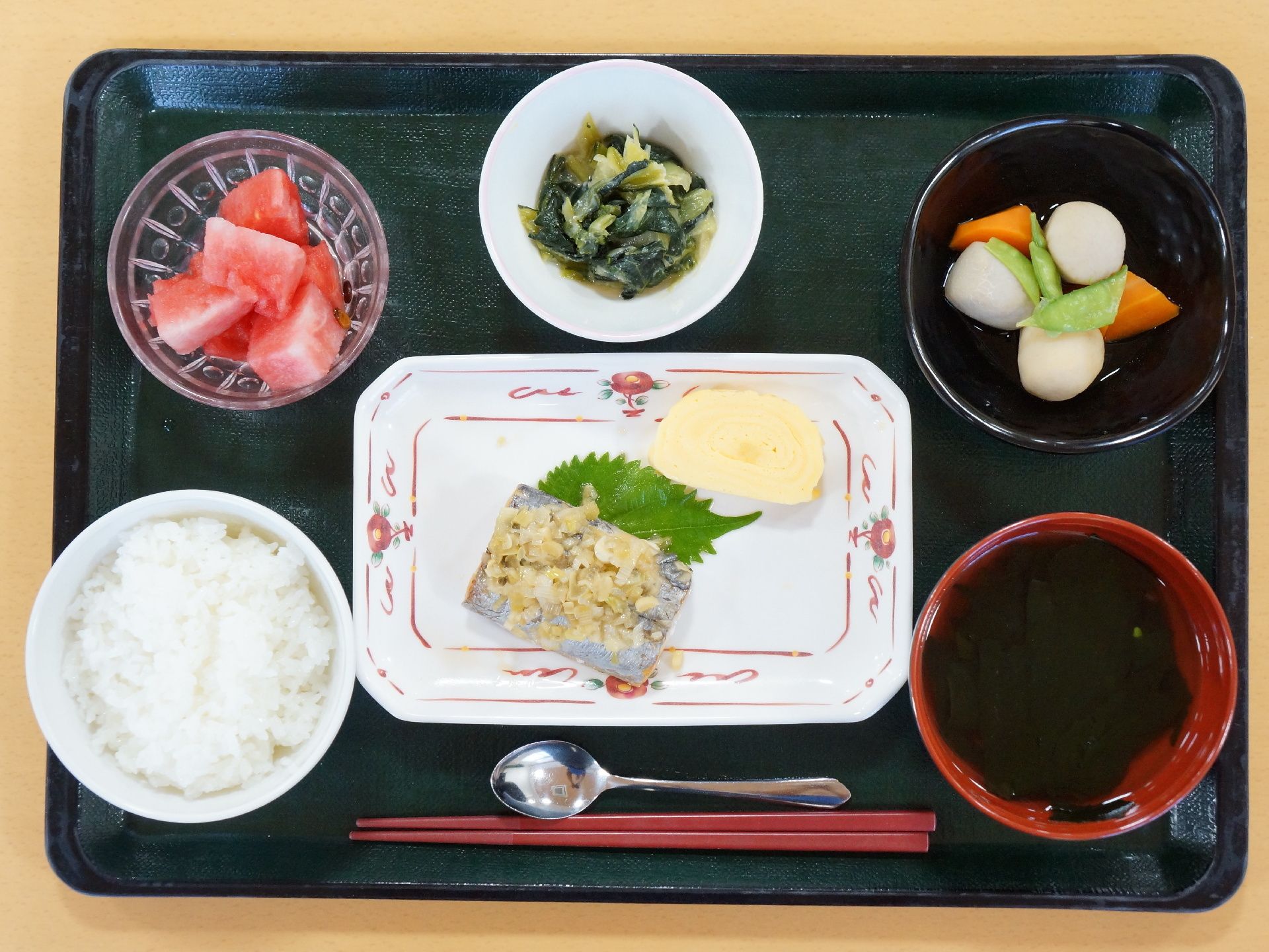 施設内で提供される、食事の一例。黒いお盆の上に、料理がきれいに並べられている。一汁三菜に、デザートがついている。