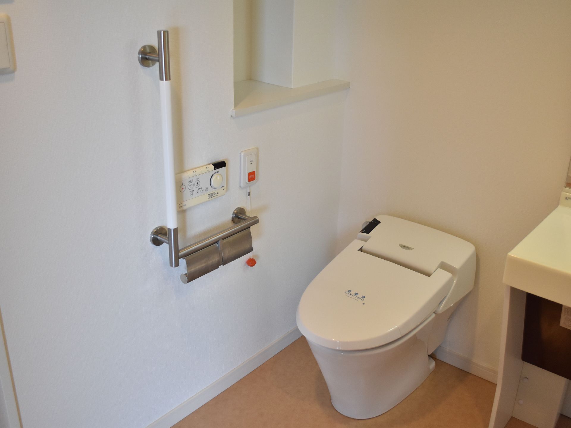 トイレには縦型の手すりが配置されているので、立ったり座ったりの動作がゆっくりできる。緊急時に備え、呼び出しボタンが設置されている。