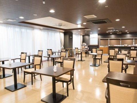 「グランメゾン迎賓館京都桂川」食堂。高い天井が開放感を演出しています。また、車椅子の方も使いやすい高さのテーブルセットが並んでいます。