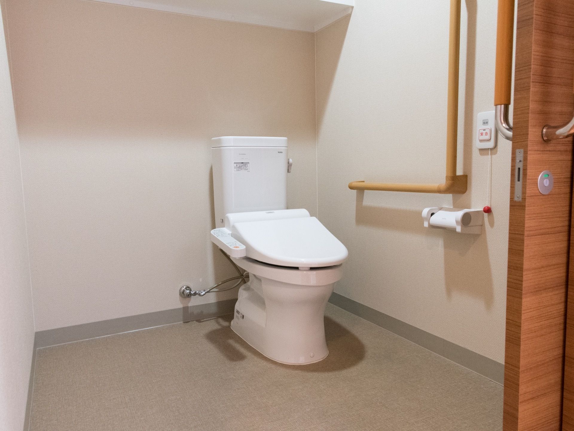 白が基調の広々とした清潔感のあるトイレである。温水洗浄便座なので、ボタン1つで操作ができて簡単かつ便利である。