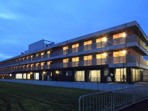 日が暮れた空と、3階建ての建物
