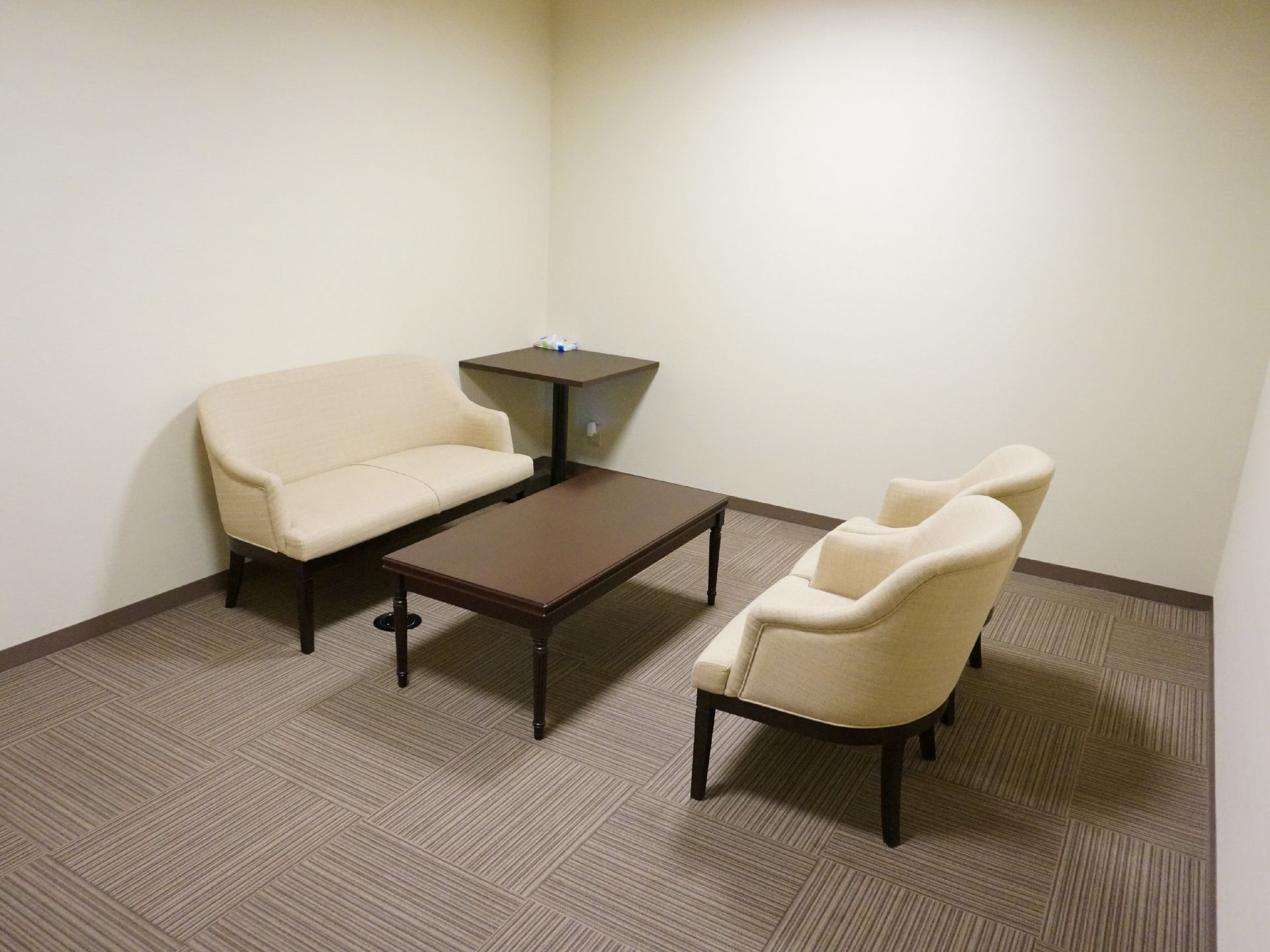 シンプルなお部屋で、ゆったりと座ることができるソファが設置されています。真ん中にテーブルがあり、サイドテーブルもあるので便利です。